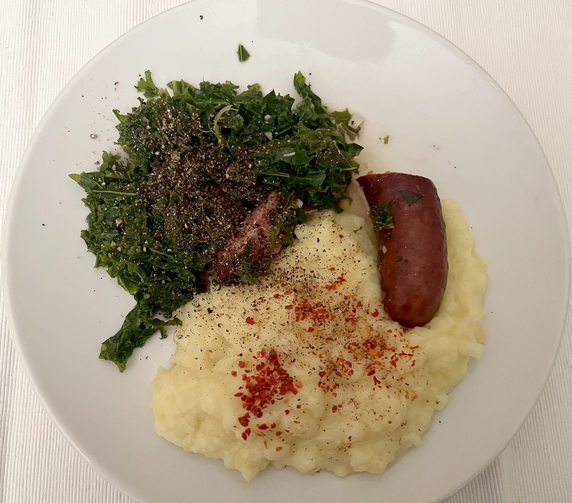 Grünkohl mit Bratwurst und Kartoffelstampf” style=